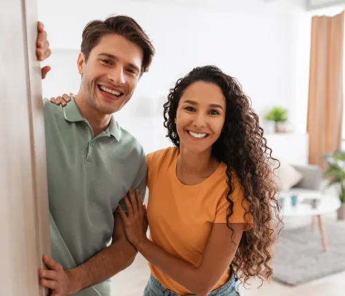 Two people looking out an open door.