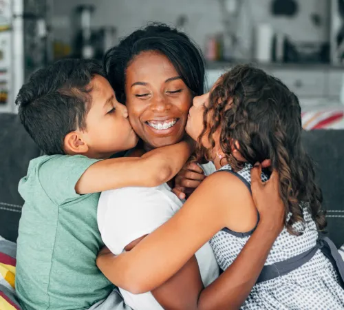 Family hugging on a couch.