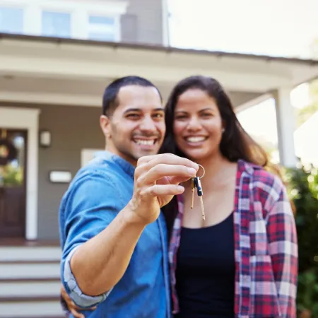 Couple holding a set of house keys.