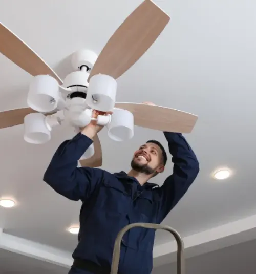 Man performing maintenance on a fan.