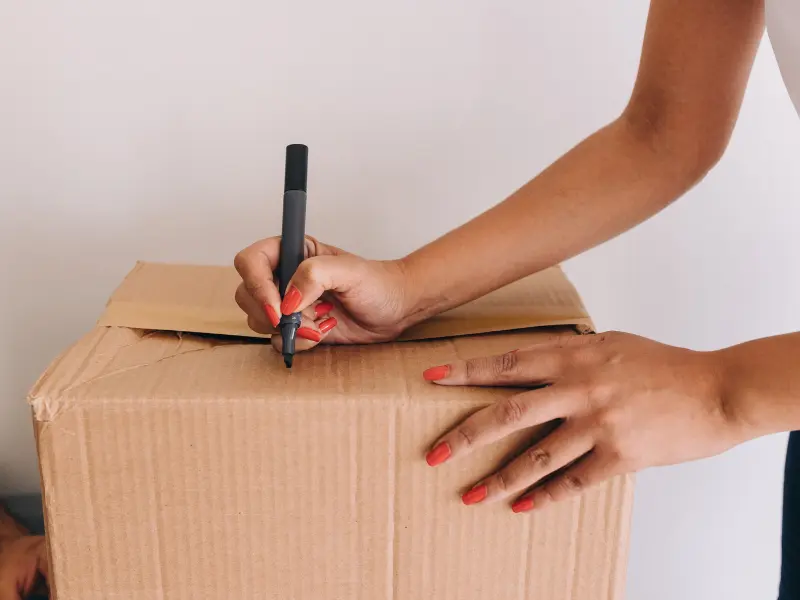 Person labeling a moving box.