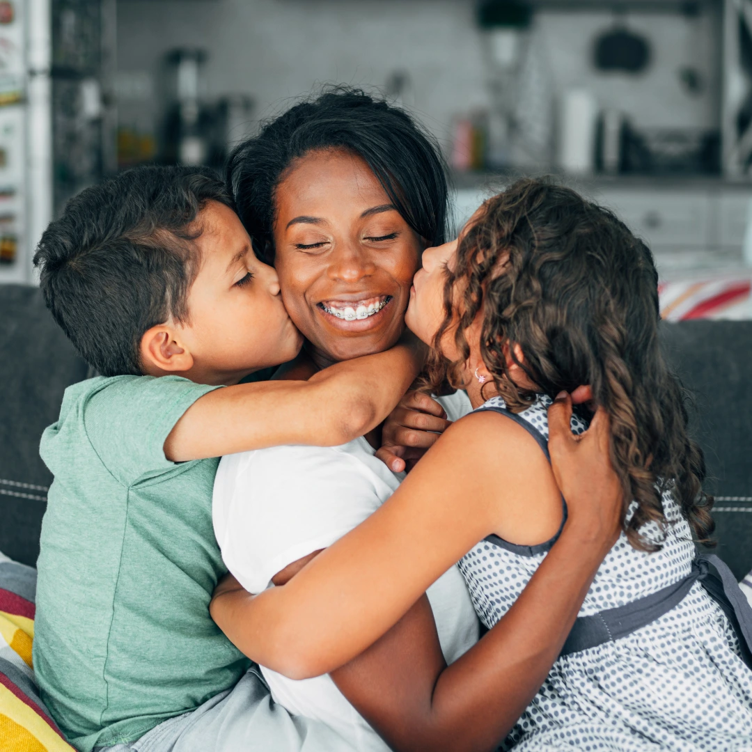 Family hugging on a couch.