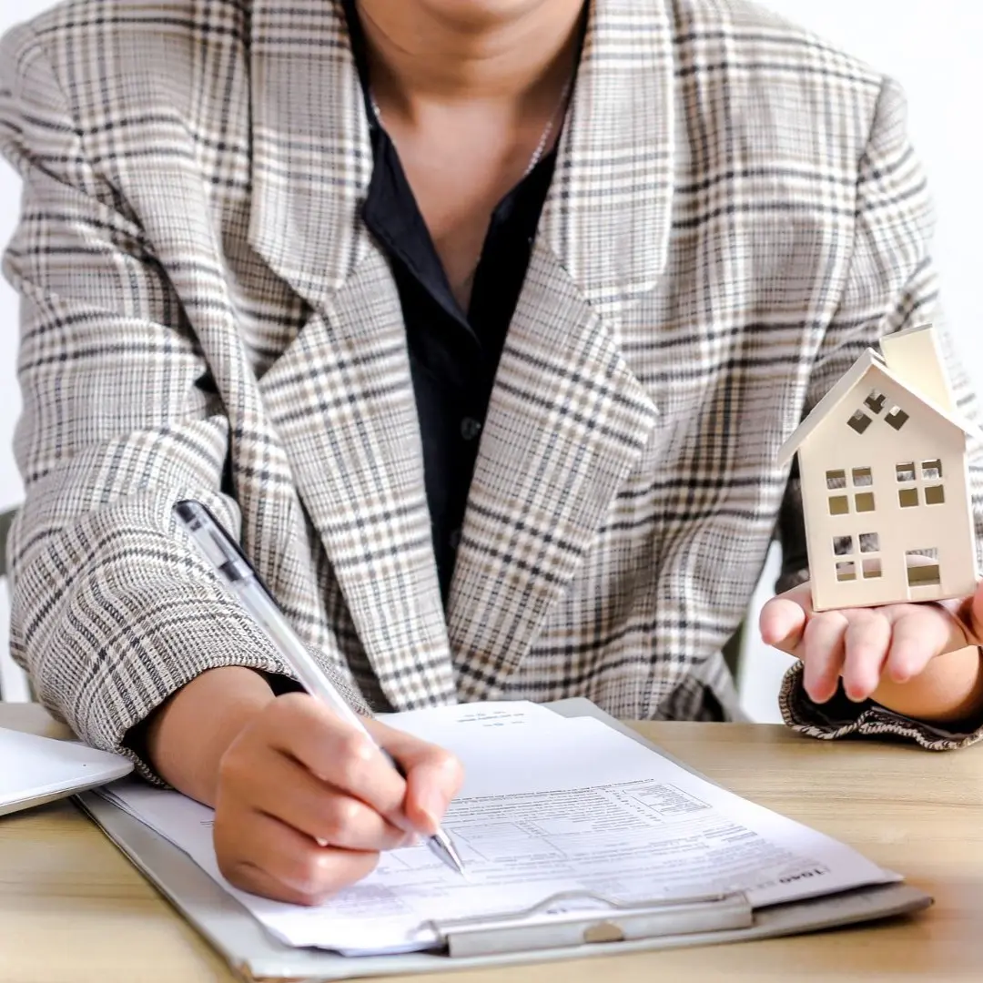 Investor reviewing BRRRR acquisition paperwork with a house model and piggy bank in Berclair, Memphis
