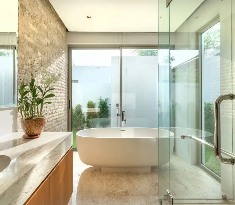Bathroom renovation in Memphis, TN with freestanding tub, glass shower, and stone tile walls.